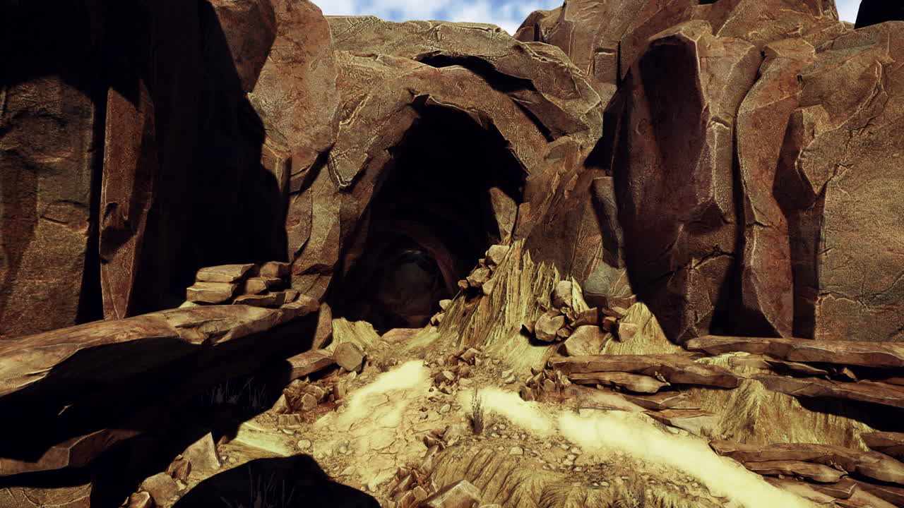 una entrada de cueva en un paisaje de montaña rocosa