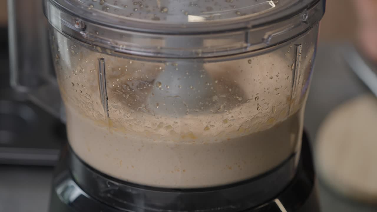 Close up of blender pureeing chickpeas into smooth hummus for healthy recipe