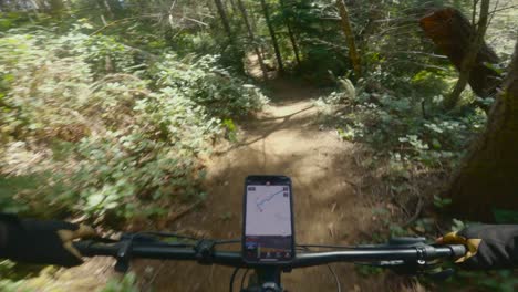 mountain biking on fast smooth banking and rolling hills in the pacific northwest with phone navigation on bike handlebars