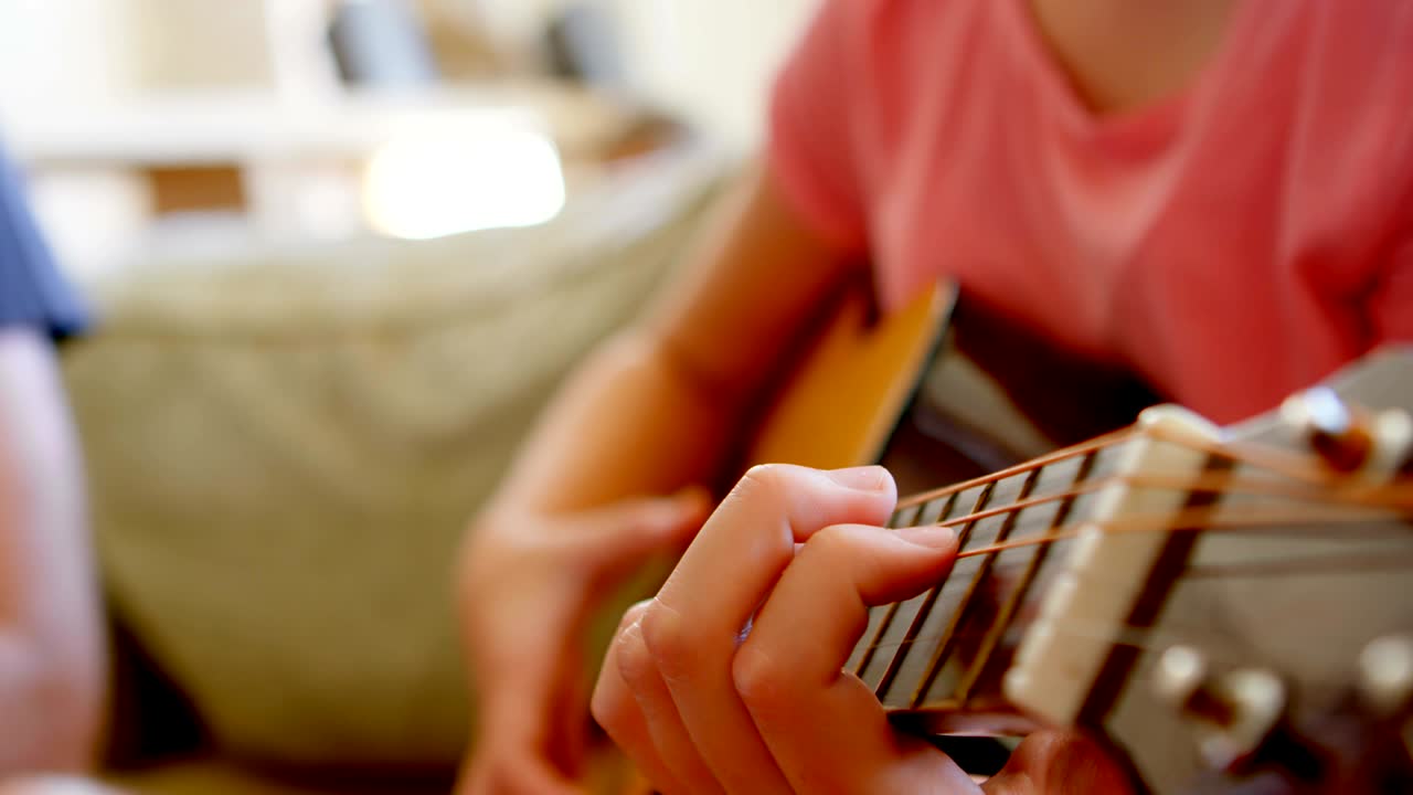 chica tocando la guitarra en la sala de estar 4k