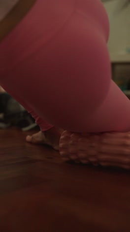 mujer estirándose con un rodillo de espuma en casa