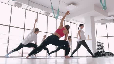 women doing stretching exercises in a modern gym with an instructor