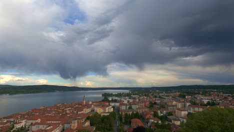 increíble lapso de tiempo de gran angular de oscuras nubes tormentosas en movimiento sobre aronacity y el lago maggiore en italia