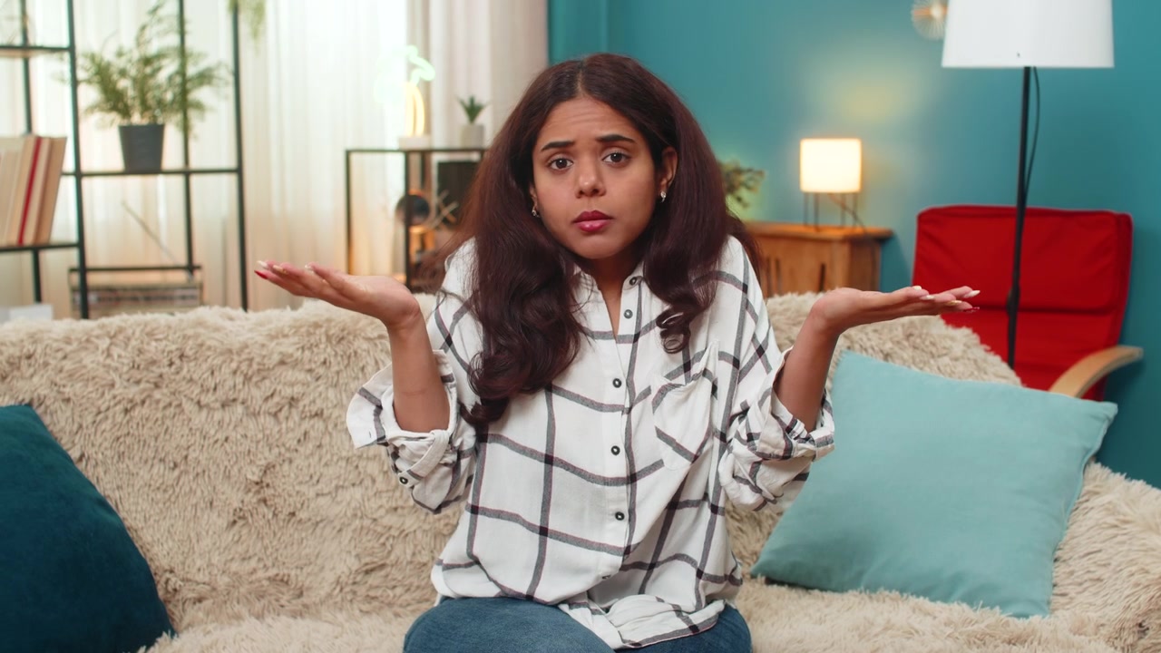 Indian woman puzzled shrug arms open raised brows showing confusion uncertainty doubt indoor gesture