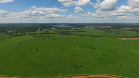 vista aérea de un paisaje rural con campos, colinas y un lago