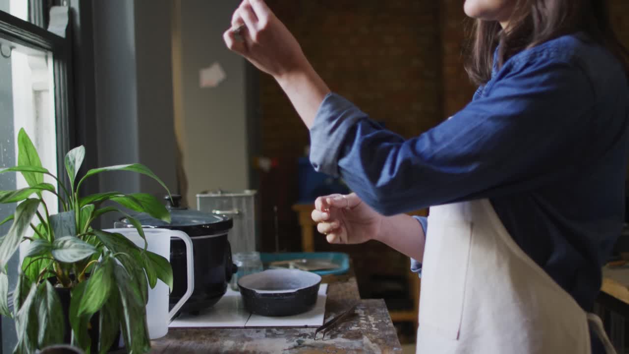 백인 여성 보석가의 중간 섹션은 애프론과 안경을 입고 보석을 준비하고 있습니다.