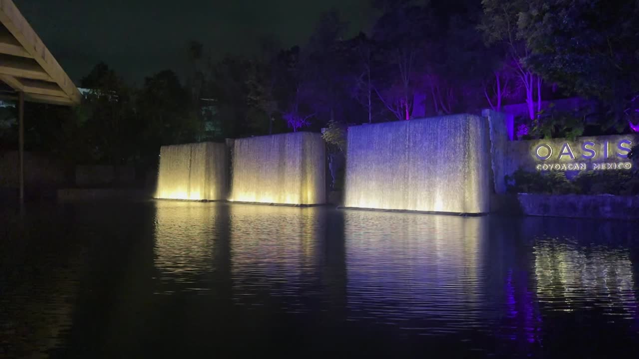 Water fountain with waterfalls in shopping plaza at night