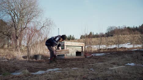 A-Man-is-Moving-Wooden-Planks-Close-to-the-Location-of-the-Hot-Tub---Static-Shot