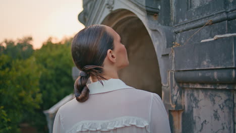 girl exploring medieval architecture looking stone arch with decorations closeup