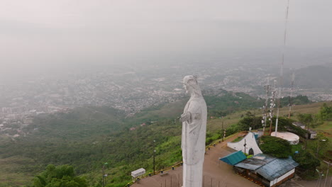 imágenes aéreas de rotación rápida de la estatua de cristo rey jesús en la cima de una montaña en la ciudad de cali, colombia