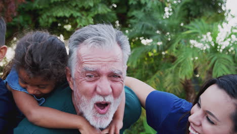 portrait of multi-generation hispanic family relaxing in garden at home together