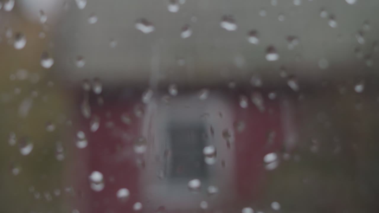 가을에 빨간 오래된 집에 창문에 비가 내리고, 핸드헬드는 중간 샷에 초점을 맞춥니다.