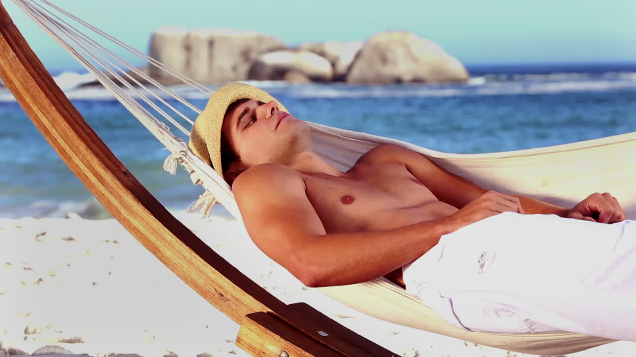 hombre guapo relajándose en una hamaca.
