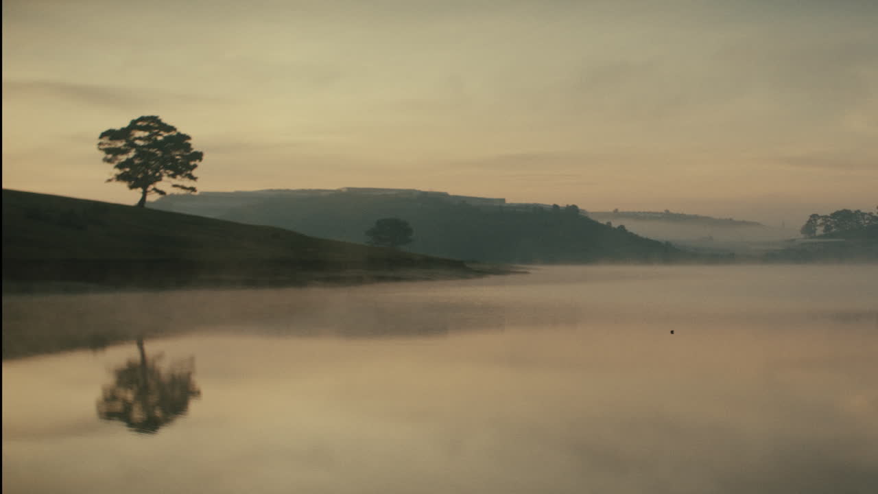 조용한 호수 위 의 안개 가 가득 한 해가 뜨는 것
