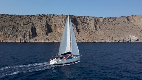 group of friends sailing on a bavaria 45ft sailboat off the coast of dokos island in the argo-saronic gulf greece mediterranean sea