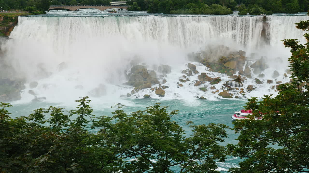 나이아가라 폭포 기슭에서 항해하는 관광객을 태운 배