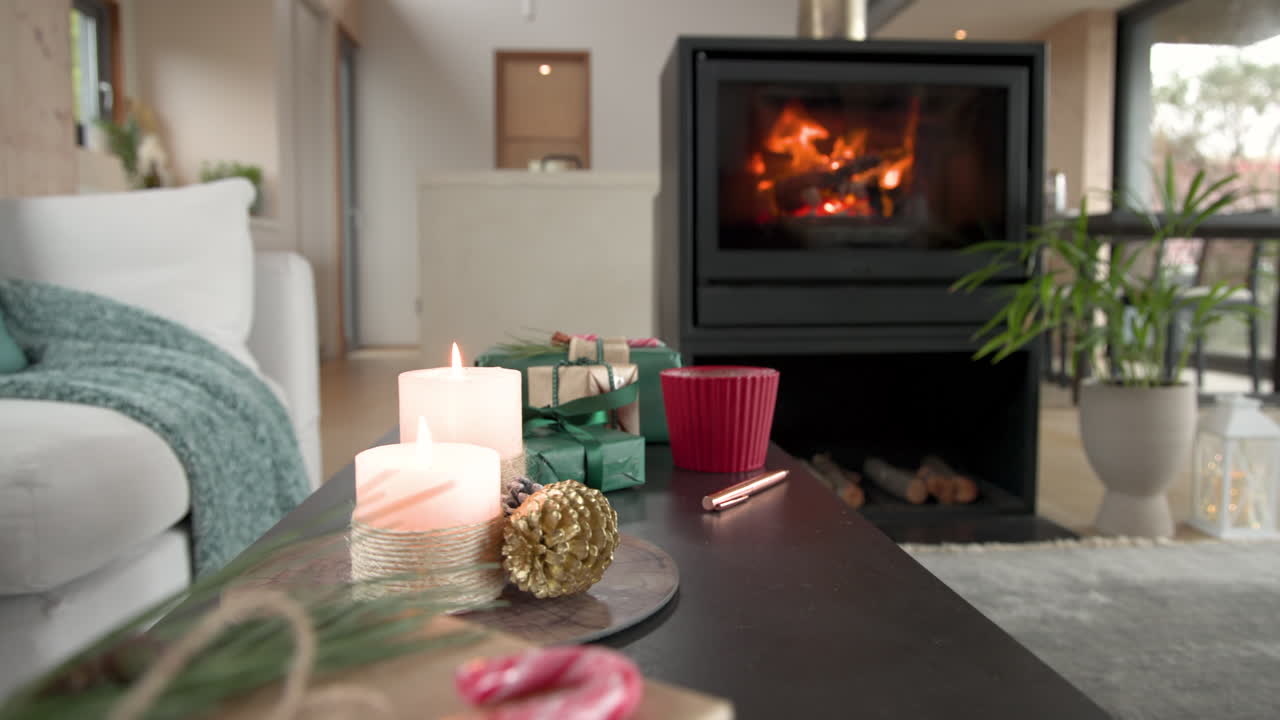 Cozy Christmas scene with candles and gifts by warm fireplace at home, copy space