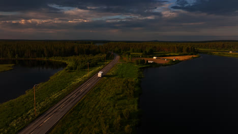 aerial view circling a rv driving on road e75, summer evening in sodankyla, finland
