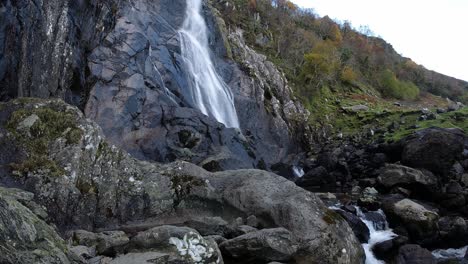 rocky time lapse cascading waterfall flowing into jagged river rocks and boulders