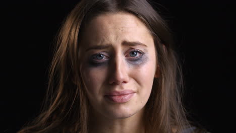 studio portrait shot of crying woman with smudged make up