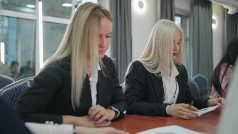 female office workers in business meeting with headmistress discussing reports and strategic plan