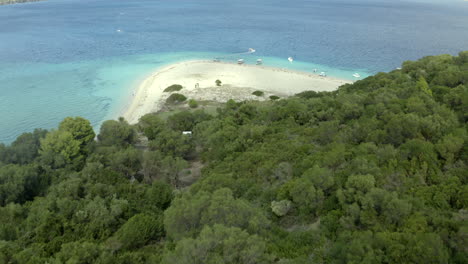 disparo de un dron cinematográfico suave sobrevolando la isla verde tropical marathonisi con playa frente a la isla de zakynthos, grecia en 4k