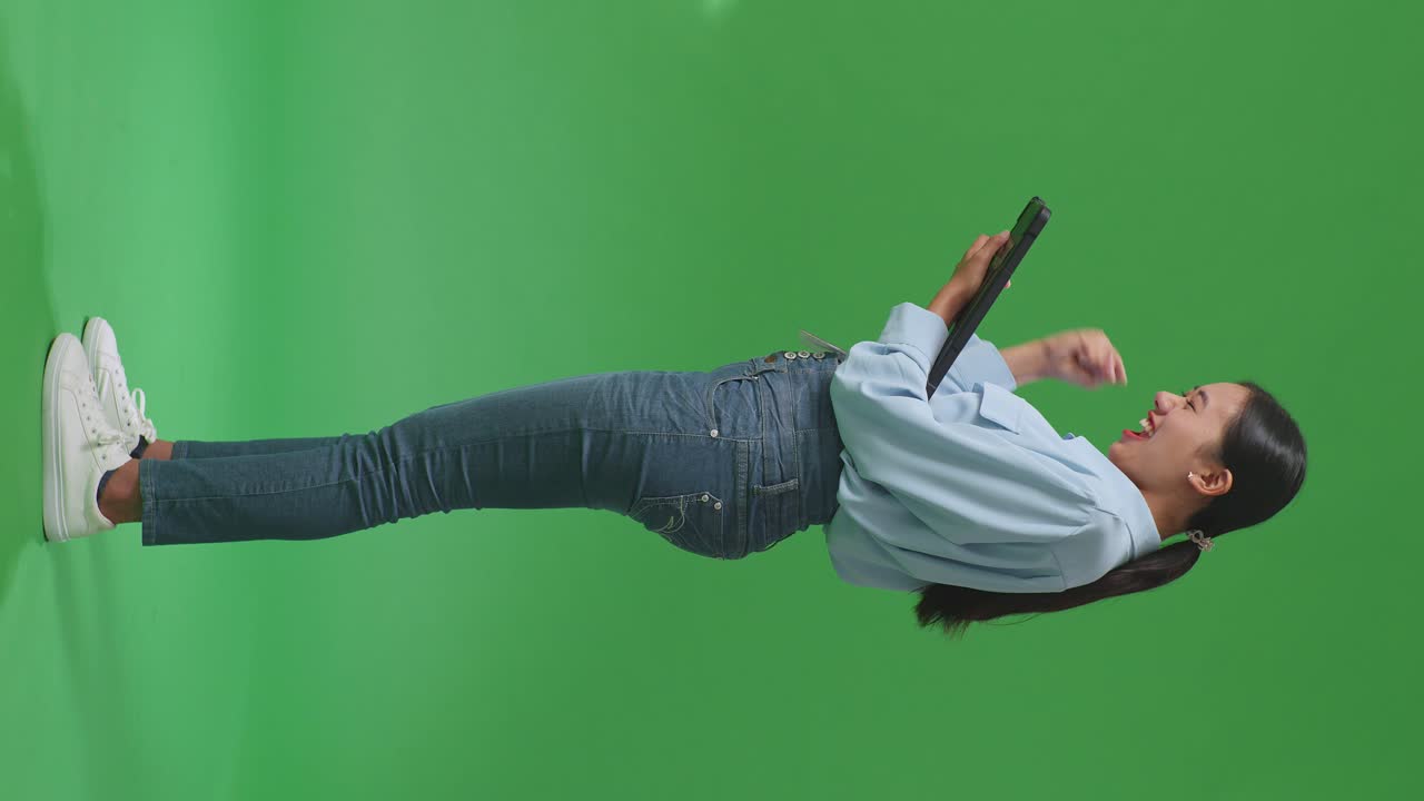 mujer celebrando con la tableta en la pantalla verde