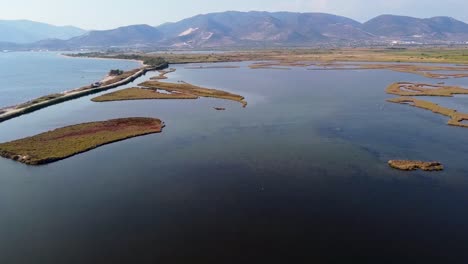 Ascending-aerial-over-natural-lagoon-used-for-fish-farms-next-to-the-sea