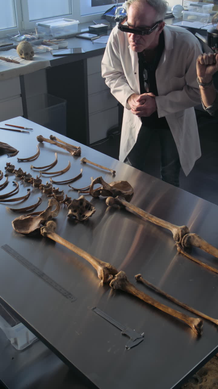 arqueólogo examinando restos esqueléticos humanos en un laboratorio