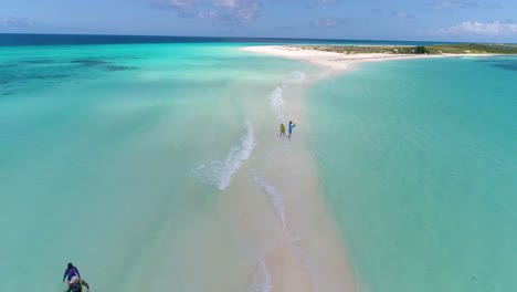 People-walking-on-white-tropical-sandbank,-stand-take-photos