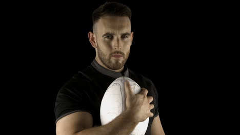 serious rugby player holding ball