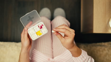 woman taking medicine in bed