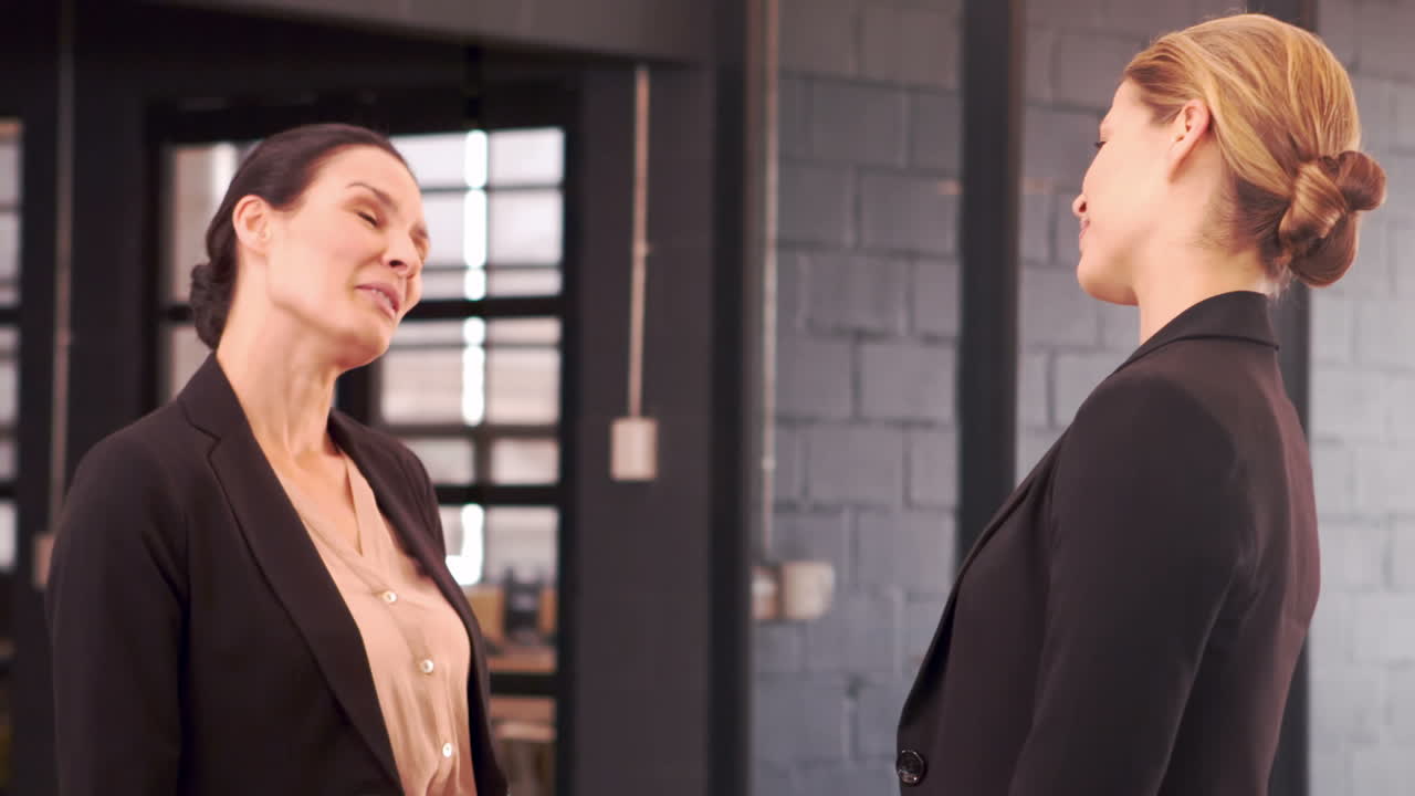 웃는 사업가 여성들이 서로 이야기하고 있습니다.