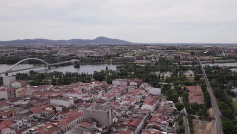 Vista-Aérea-De-La-Ciudad-De-Mérida-En-España,-El-Puente-Lusitania-Y-Las-Montañas-Al-Fondo.