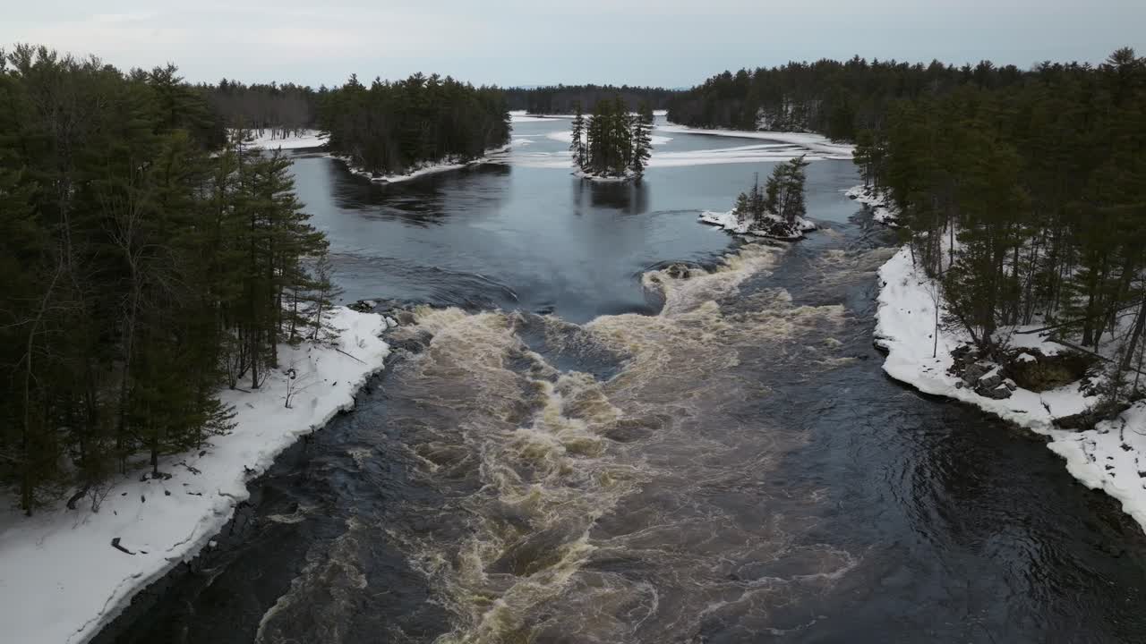 inversión de drone de un río en movimiento rápido en el desierto canadiense durante el invierno