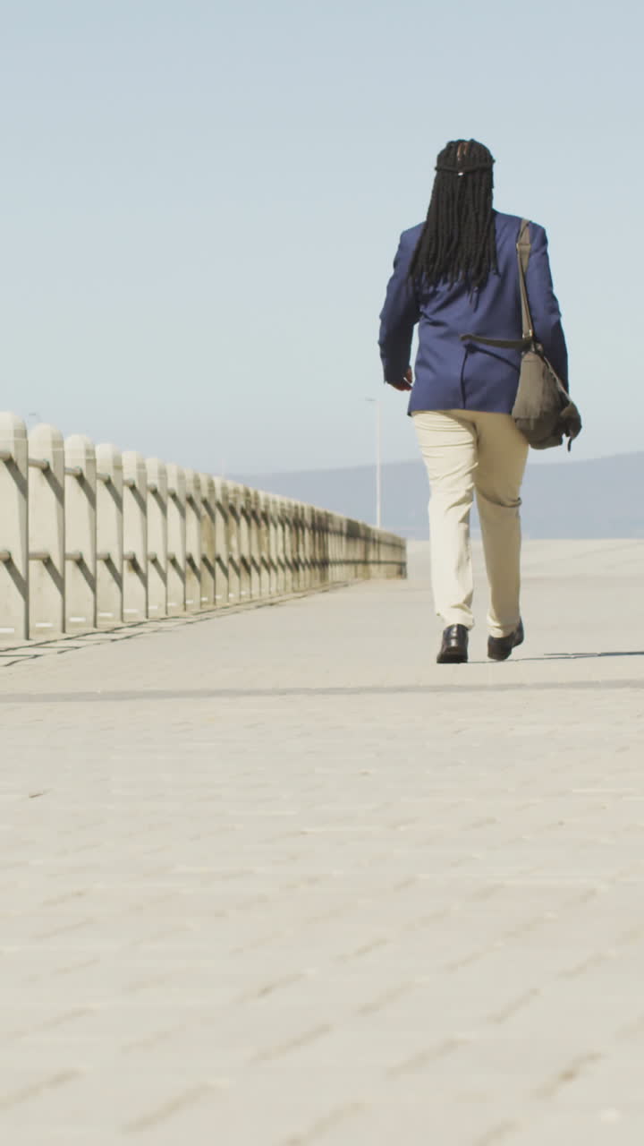 video de atrás de padre e hijo afroamericanos en scooter pasando tiempo en el mar