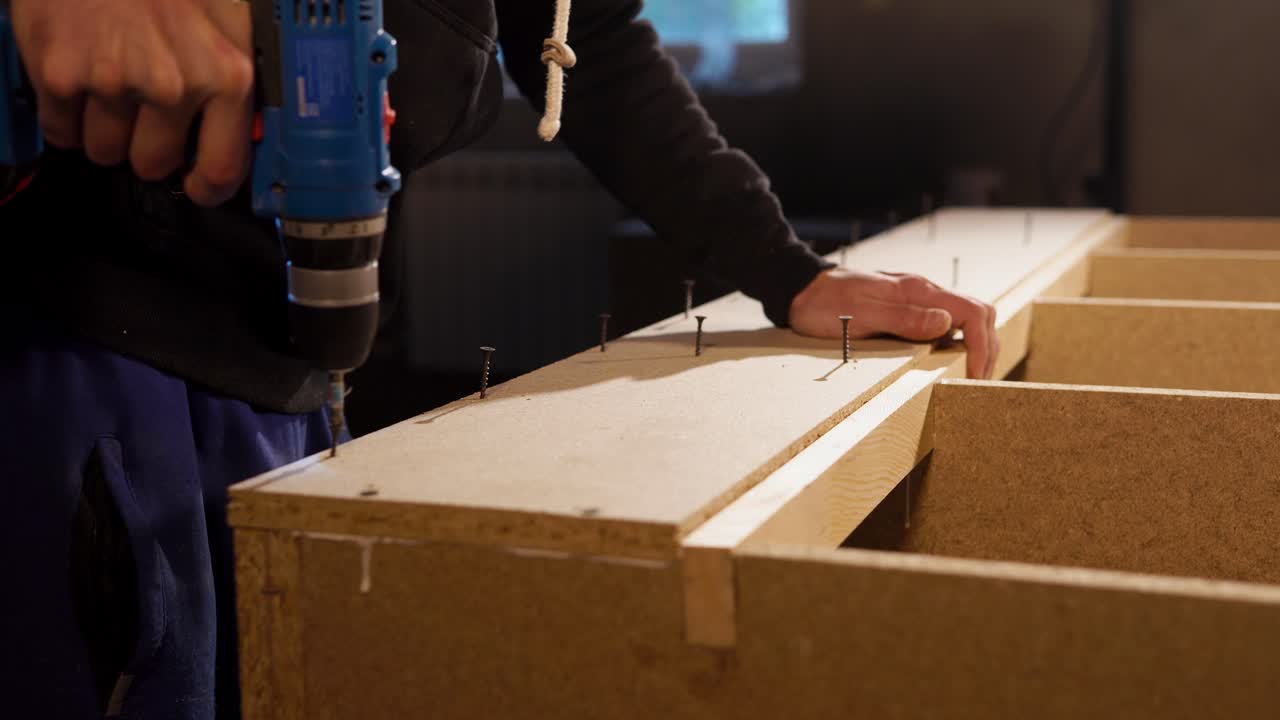 나무 선반 단위를 조립하는 사람