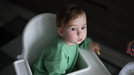 baby eating in high chair