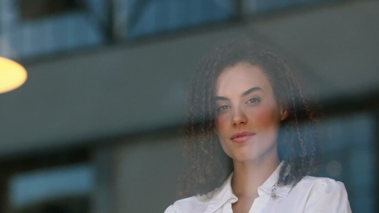 Chica hipster sonriente mirando por la ventana