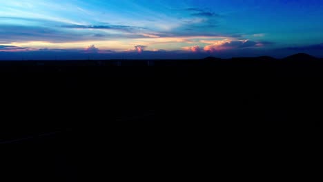 Drone-shot-flying-up-against-a-Sunset-sky-with-plant-and-river-in-foreground