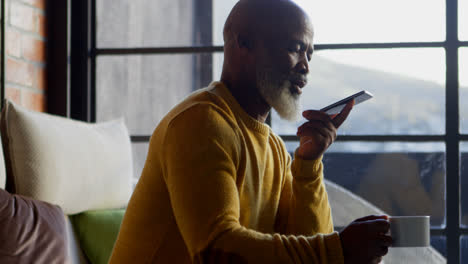 Senior-man-talking-on-mobile-phone-in-living-room-4k