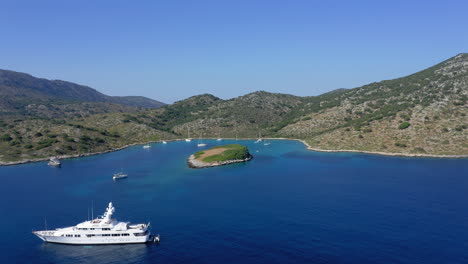 Aerial:-Flying-towards-paradise-bay-of-the-island-of-Kira-Panagia-in-Sporades,-Greece-with-amazing-turquoise-and-emerald-crystal-clear-sea