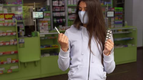 una mujer comprando medicamentos en una farmacia con una máscara.