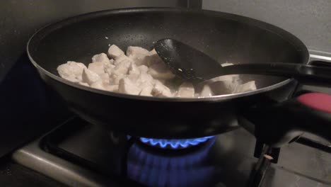 Chicken-Meat-For-Pasta-Sauce-Simmering-On-Skillet-Pan-With-Black-Cooking-Spoon-Over-Medium-Fire