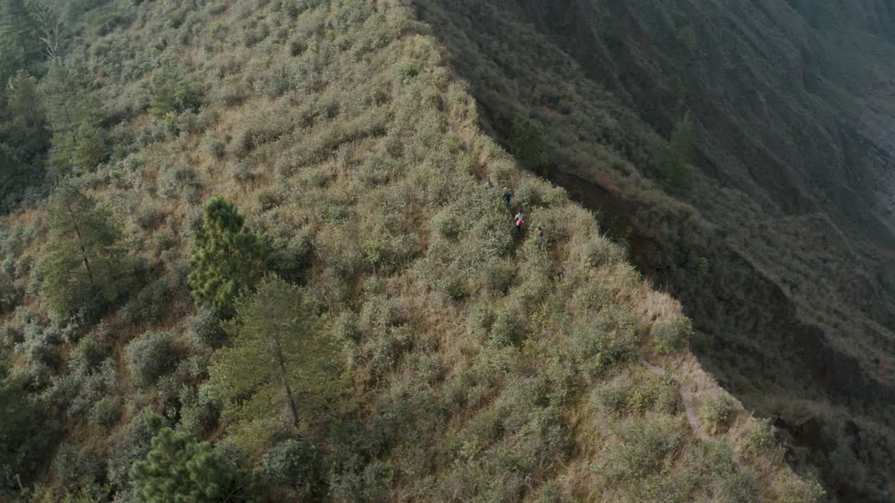 excursionistas caminando por un sendero rocoso empinado con vistas al cráter del volcán el chichon en chiapas, méxico