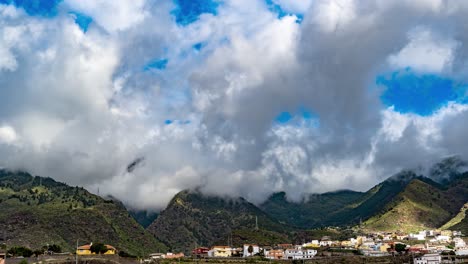 lapso de tiempo sobre un pueblo de montaña con nubes blancas esponjosas girando alrededor