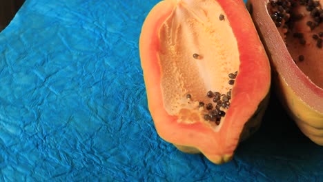 papaya fresca en rodajas sobre mesa azul