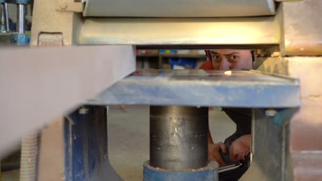 man operating a woodworking planer machine