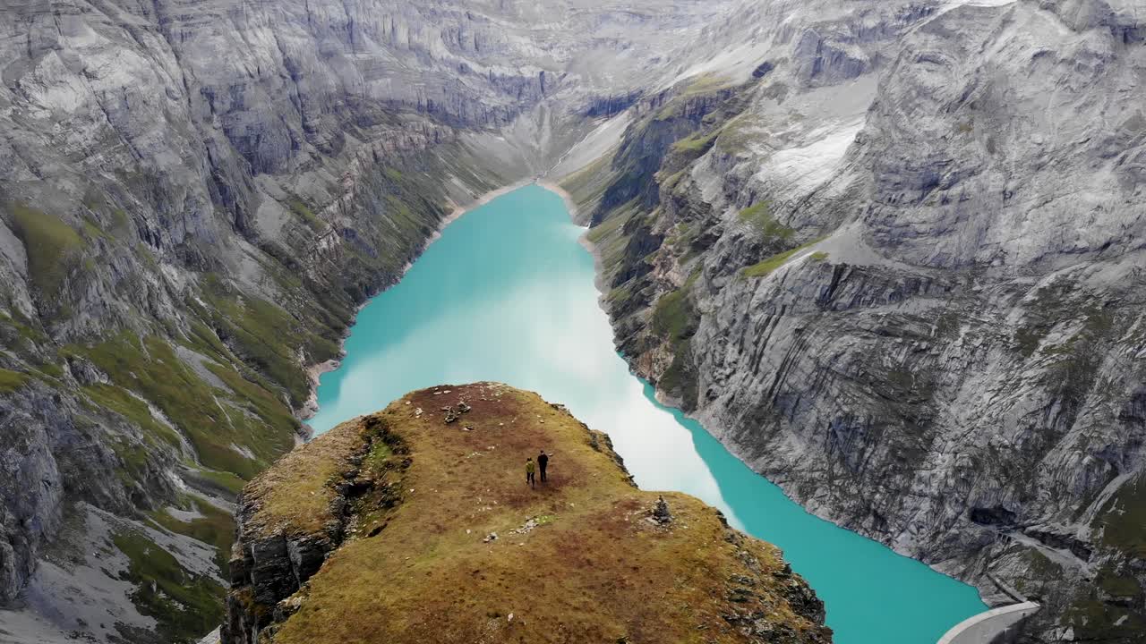 un paso elevado sobre los excursionistas que caminan hacia un mirador sobre el lago limernsee en glaris, suiza, con vistas a los acantilados y el paisaje de los alpes suizos