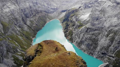 Eine-überführung-über-Wanderer,-Die-Zu-Einem-Aussichtspunkt-über-Dem-Limmernsee-In-Glarus,-Schweiz,-Mit-Blick-Auf-Die-Klippen-Und-Die-Landschaft-Der-Schweizer-Alpen-Gehen